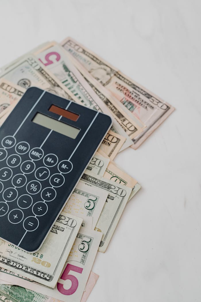 Calculator and US dollar banknotes, symbolizing finance and budgeting.